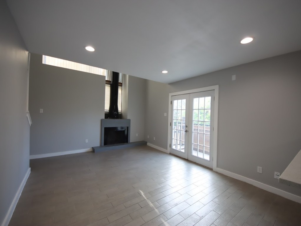 a view of empty room with wooden floor and fireplace