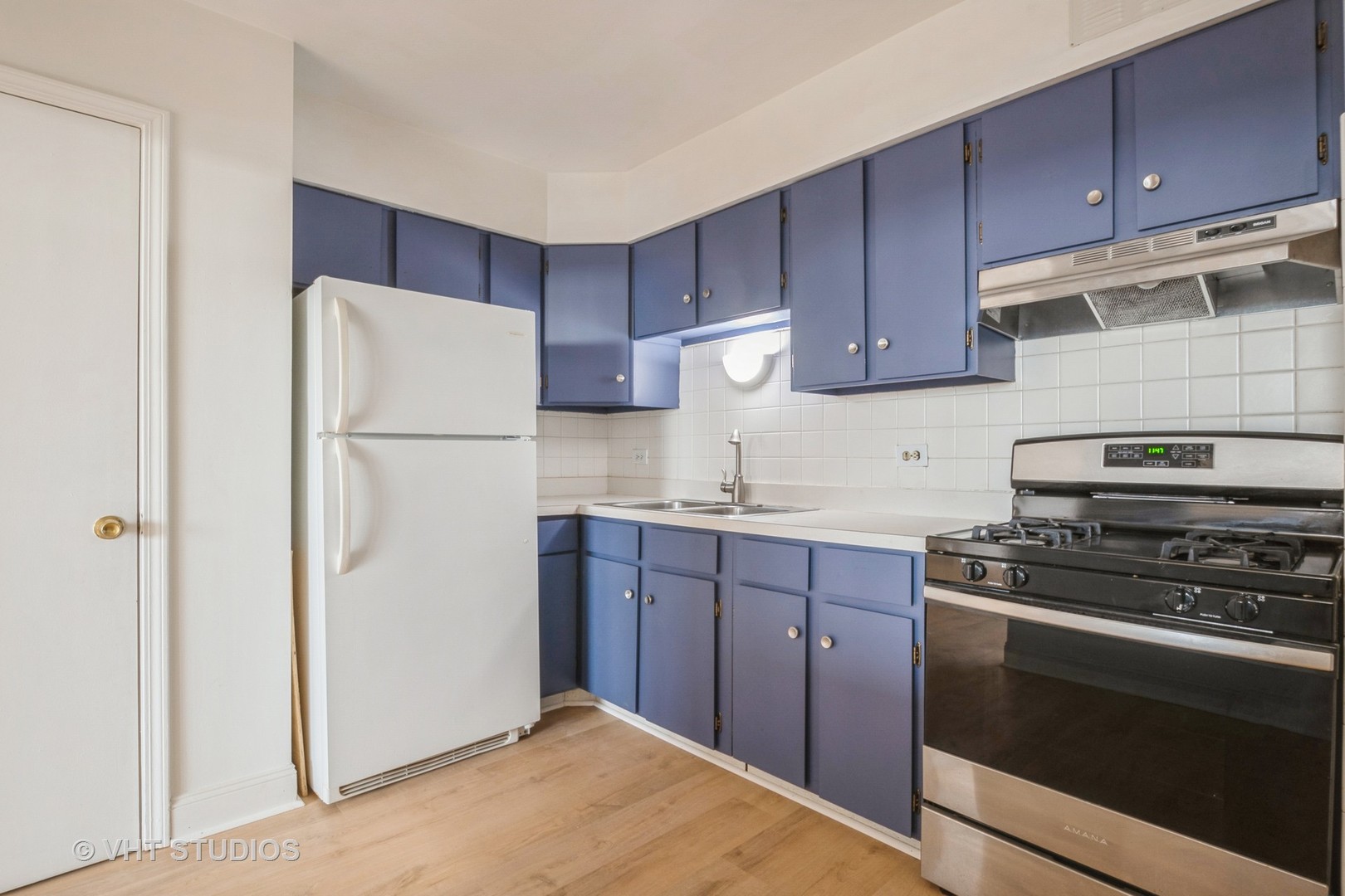 a kitchen with a refrigerator sink and cabinets