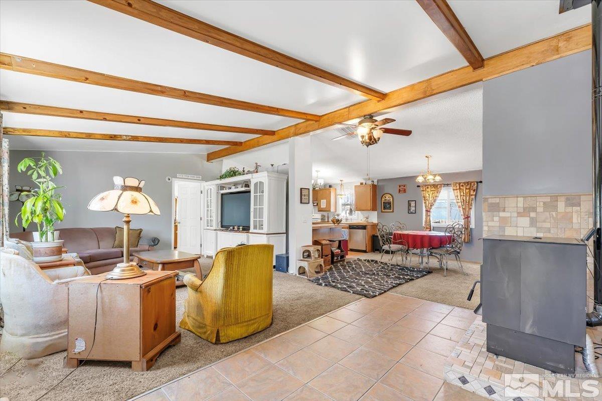 a living room with couches and kitchen view with a large window