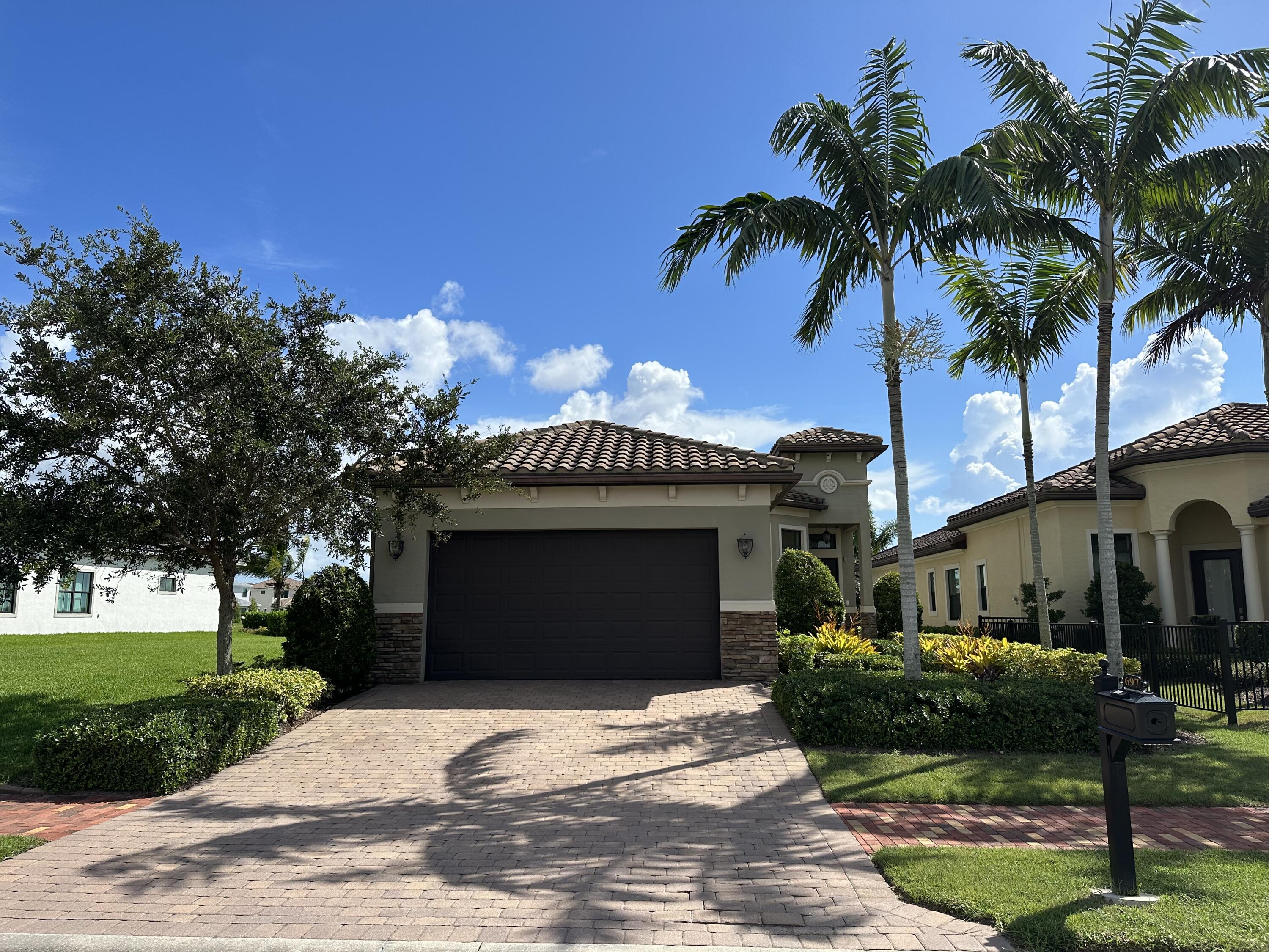 a front view of a house with garden and parking