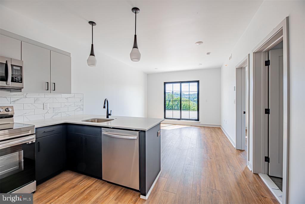 a kitchen with stainless steel appliances granite countertop a sink cabinets and wooden floor