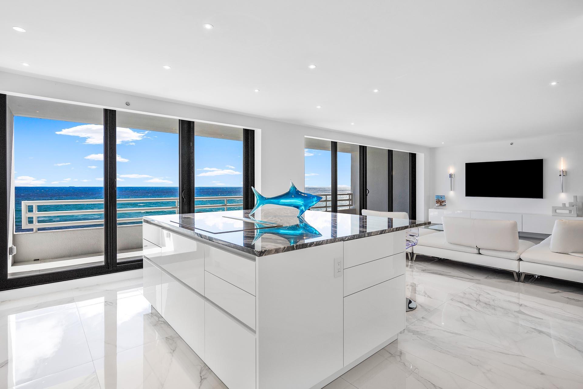 a living room with stainless steel appliances kitchen island granite countertop a sink and a flat screen tv