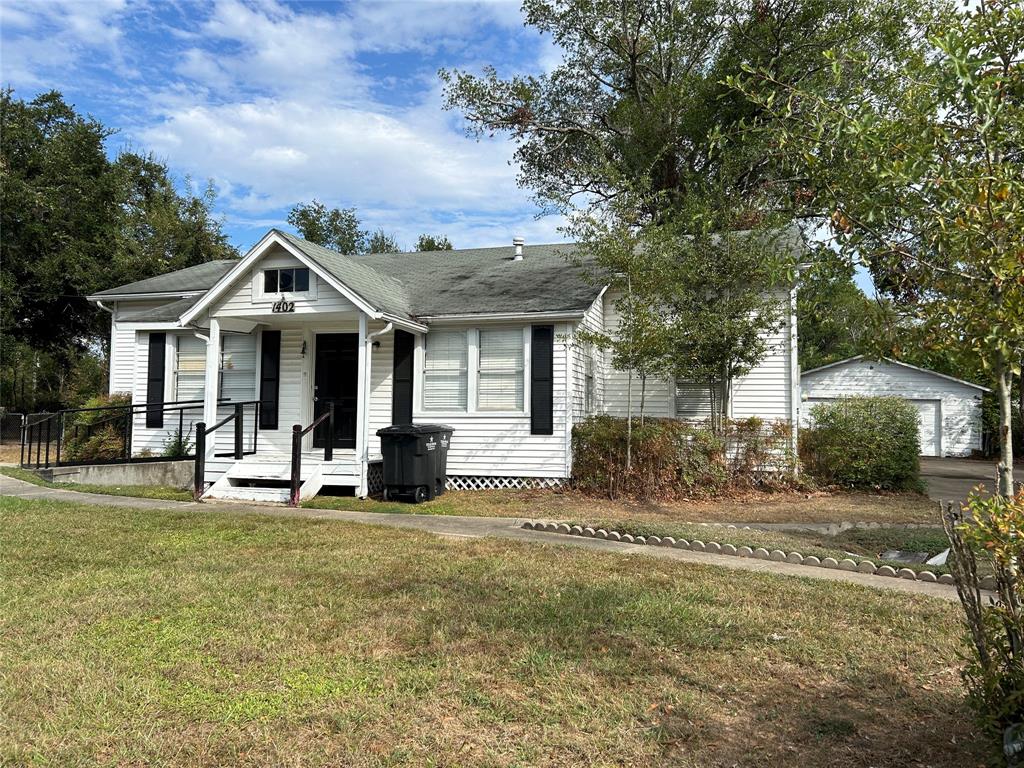 a front view of a house with a yard and trees