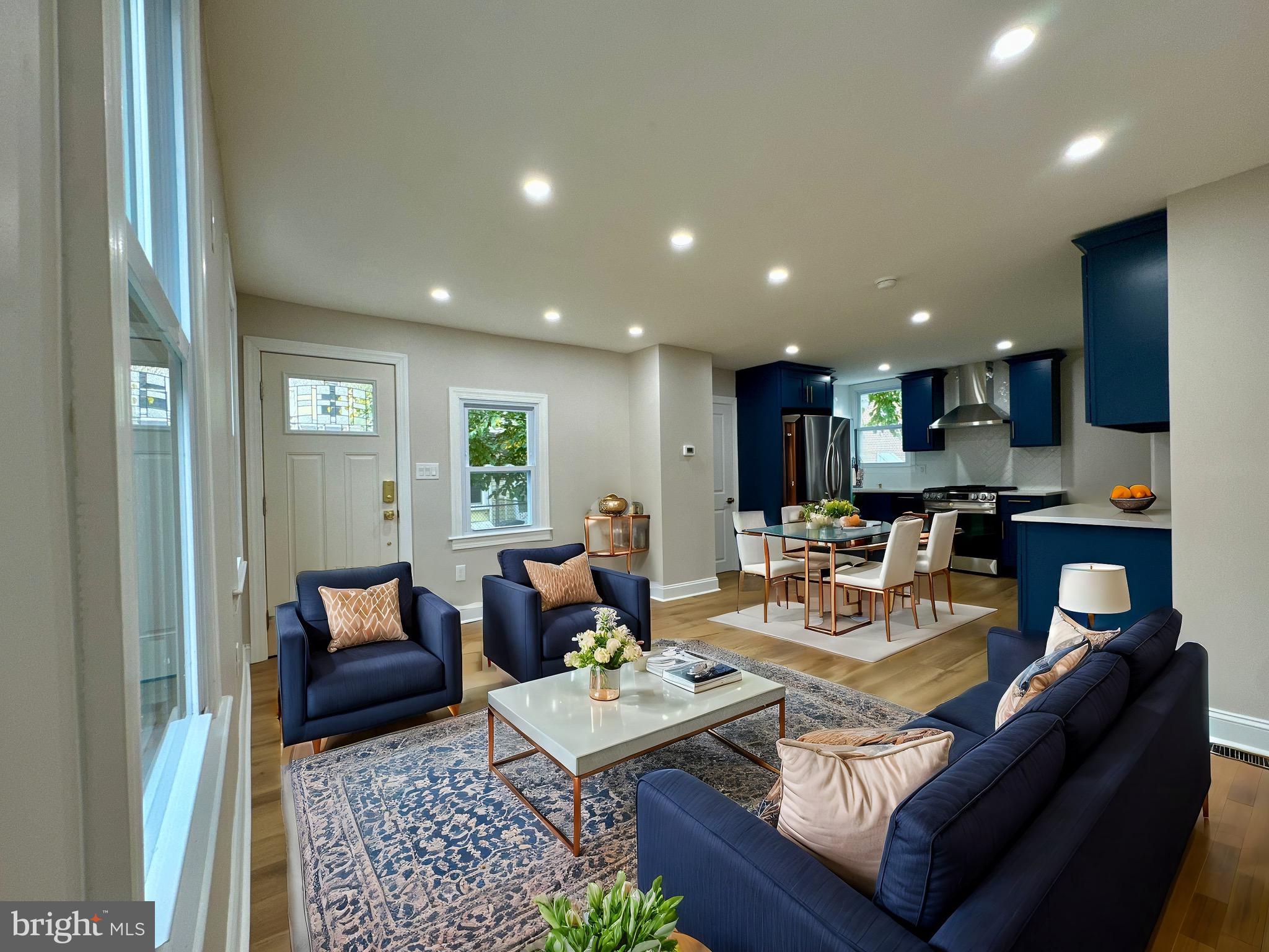 a living room with furniture and a dining table with kitchen view