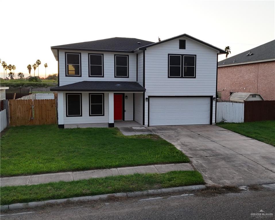 a front view of a house with a garden and yard