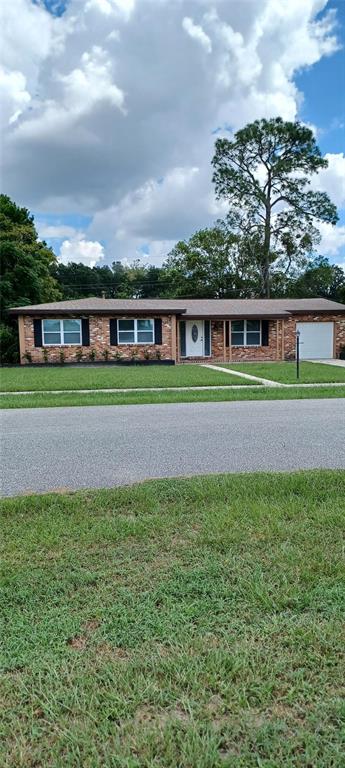 a front view of a house with a yard and trees