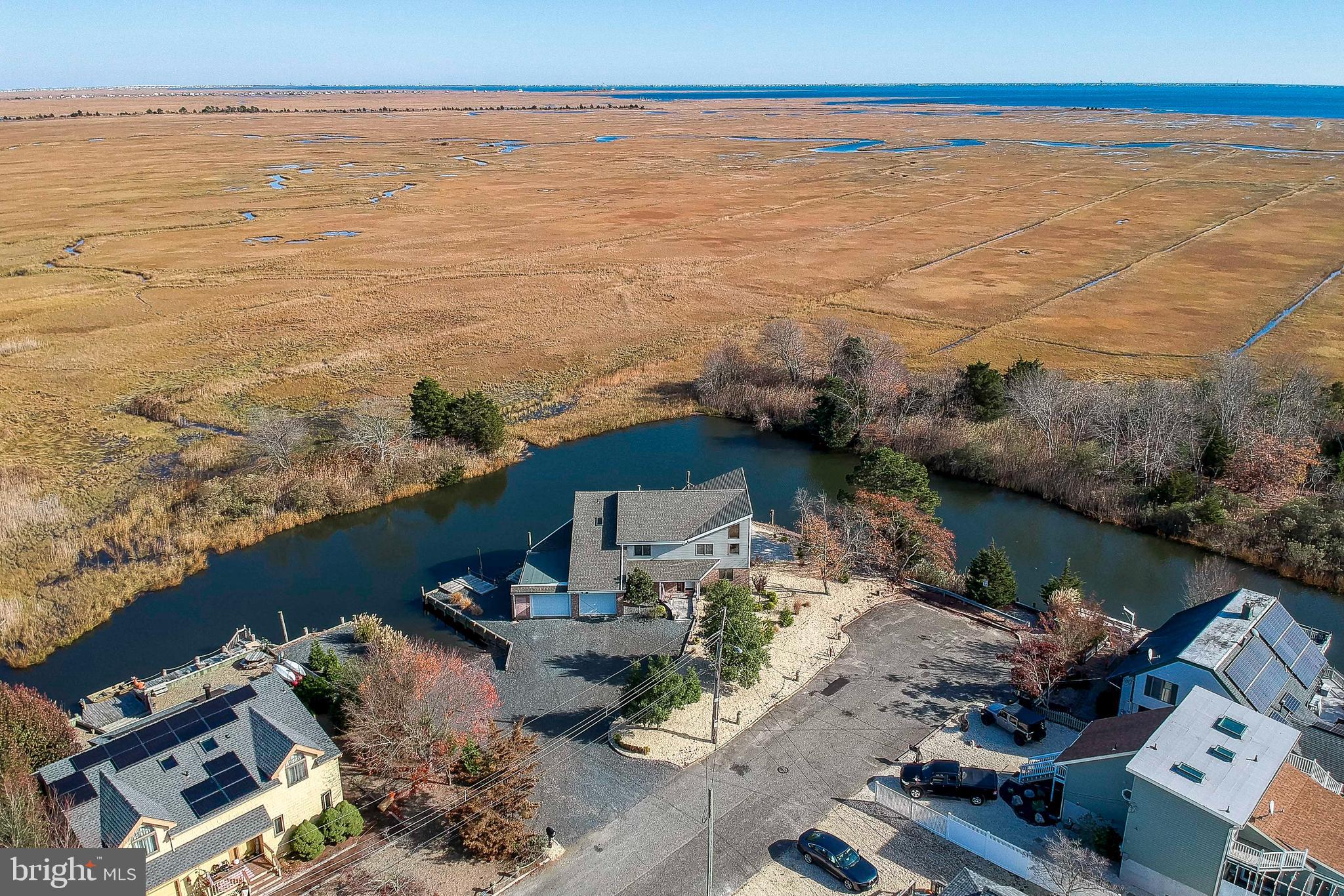 an aerial view of ocean and residential houses with outdoor space