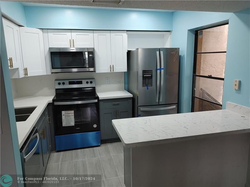 a kitchen with stainless steel appliances a stove a microwave and a refrigerator