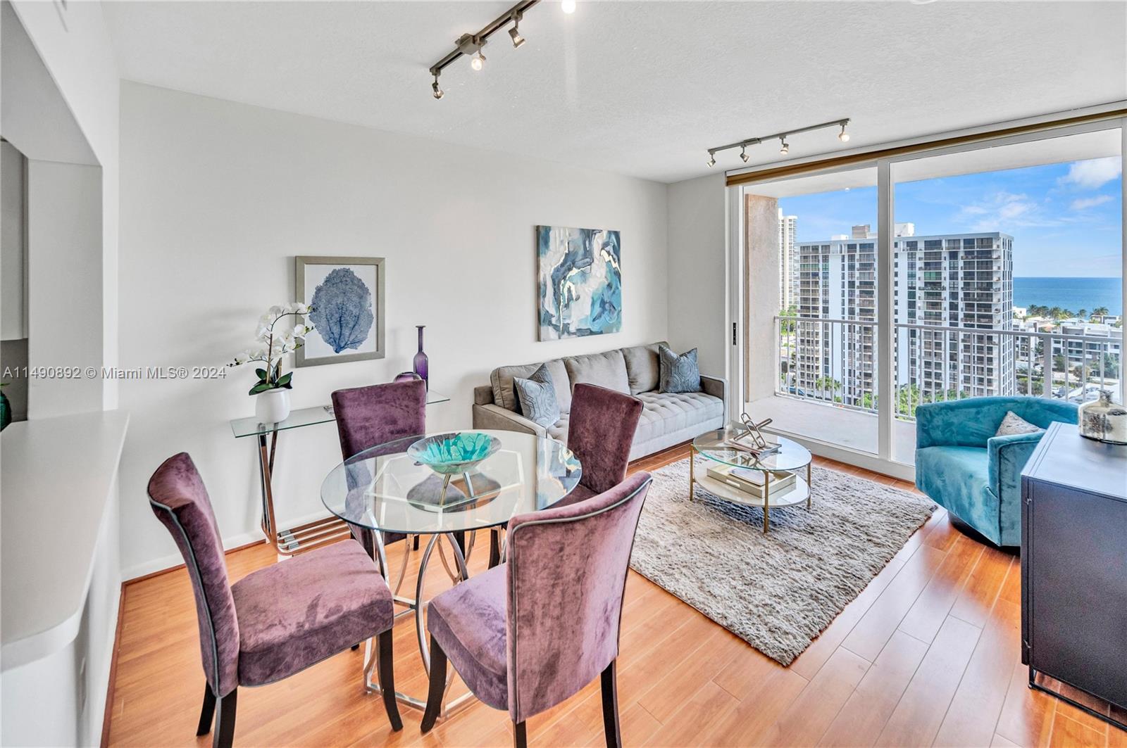 a dining room with furniture a large window and wooden floor