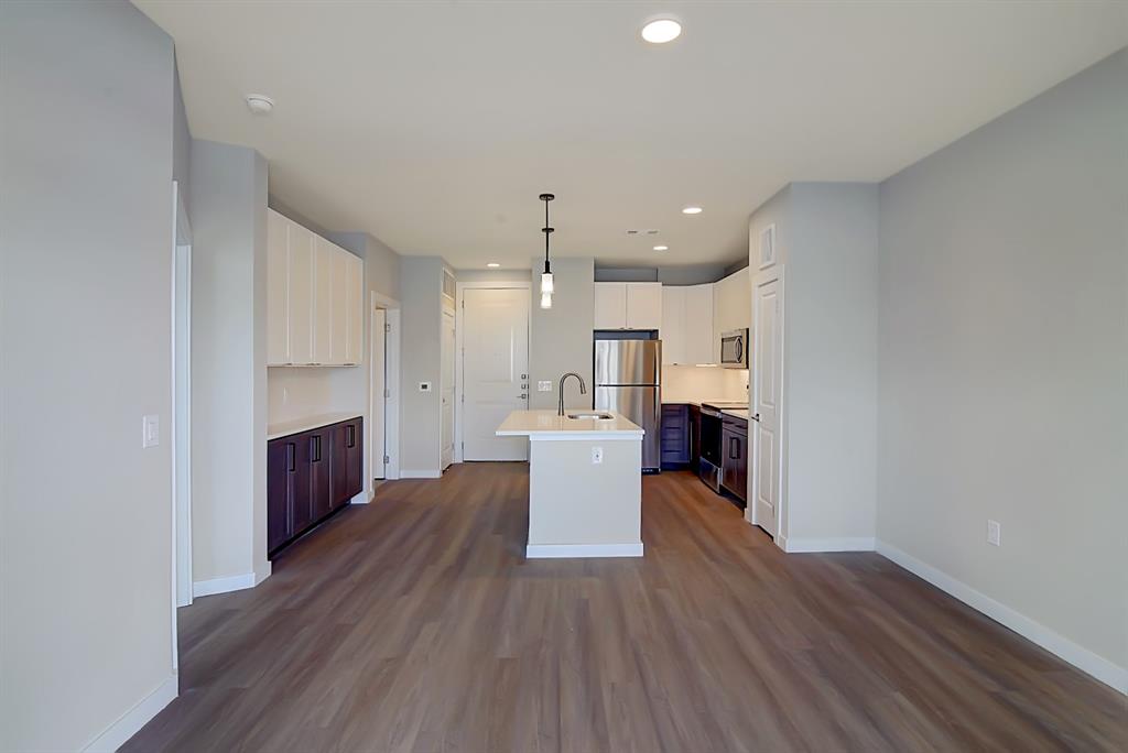 a view of kitchen with wooden floor and electronic appliances