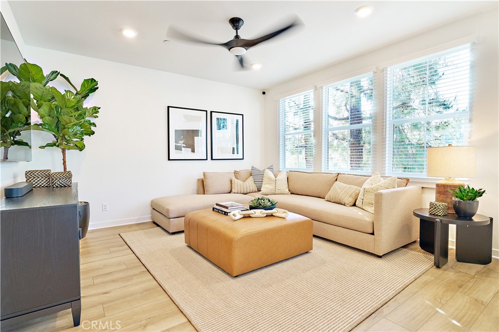 a living room with furniture potted plant and a large window