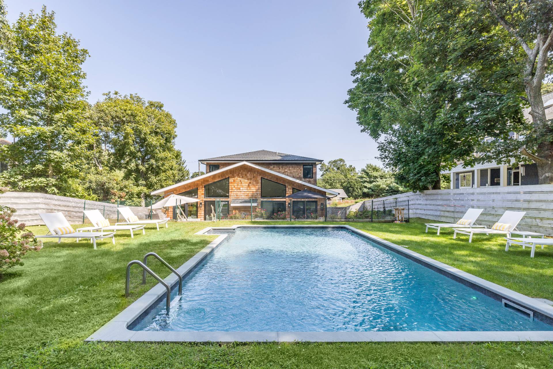 a view of an house with swimming pool and yard