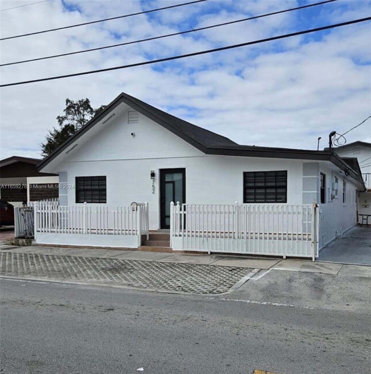 a view of a house with a fence in front of it