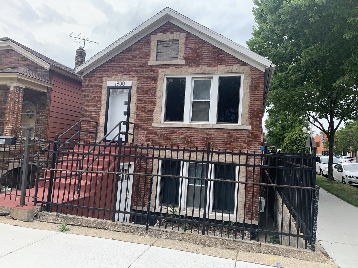 a front view of a house with iron fence