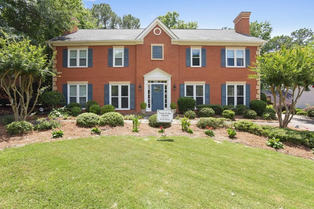 a front view of house with yard and trees around