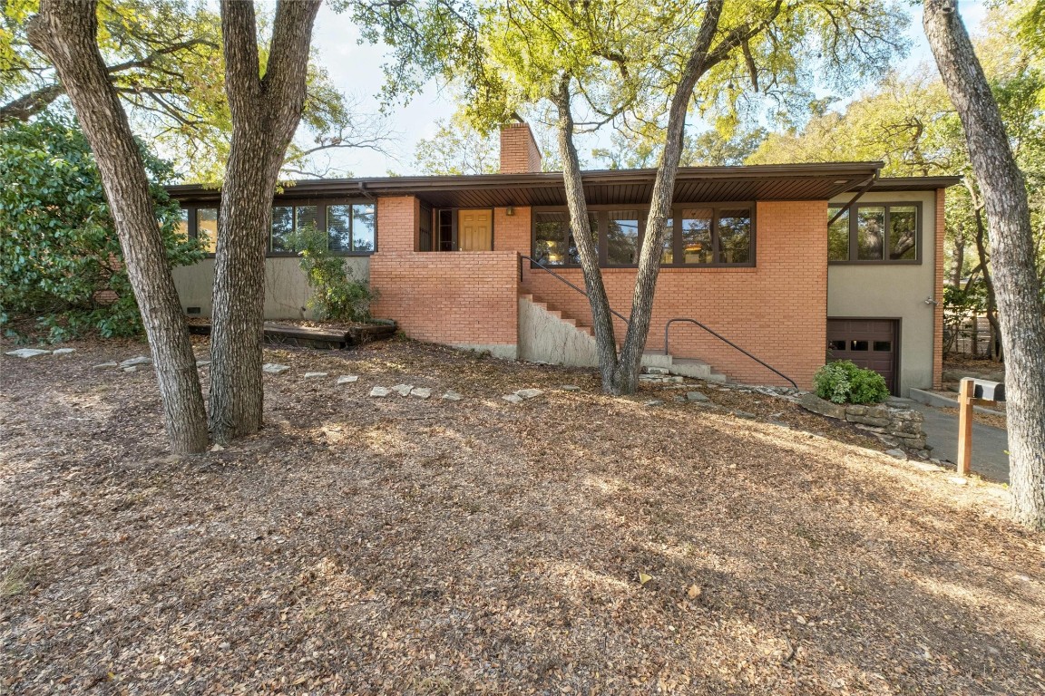 a view of a house with backyard and a tree