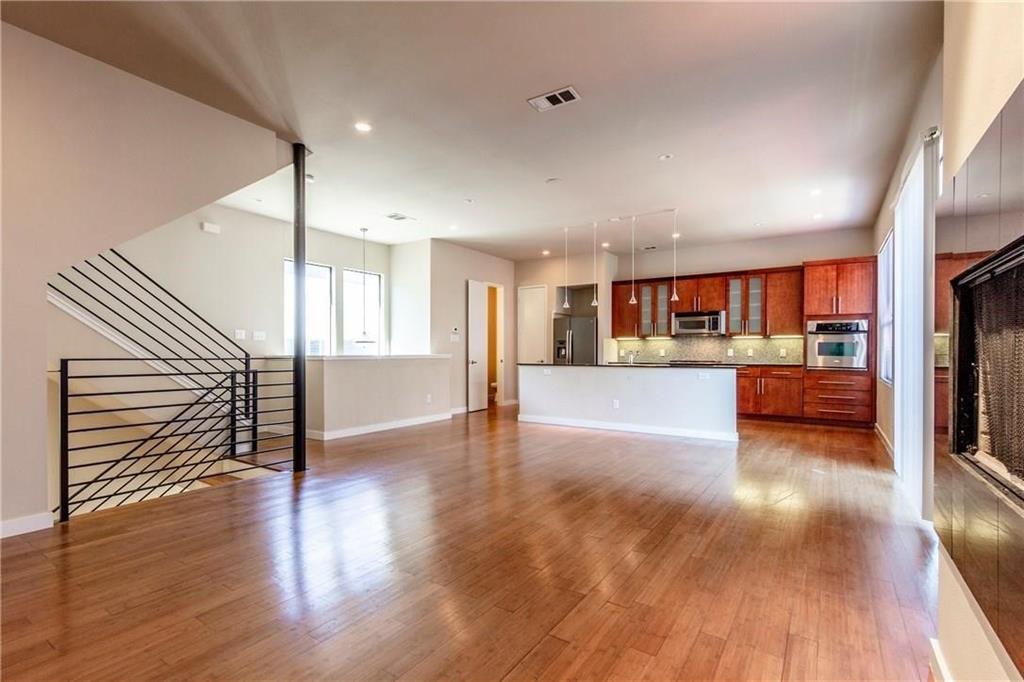 a view of a kitchen with a sink and dishwasher a refrigerator with wooden floor