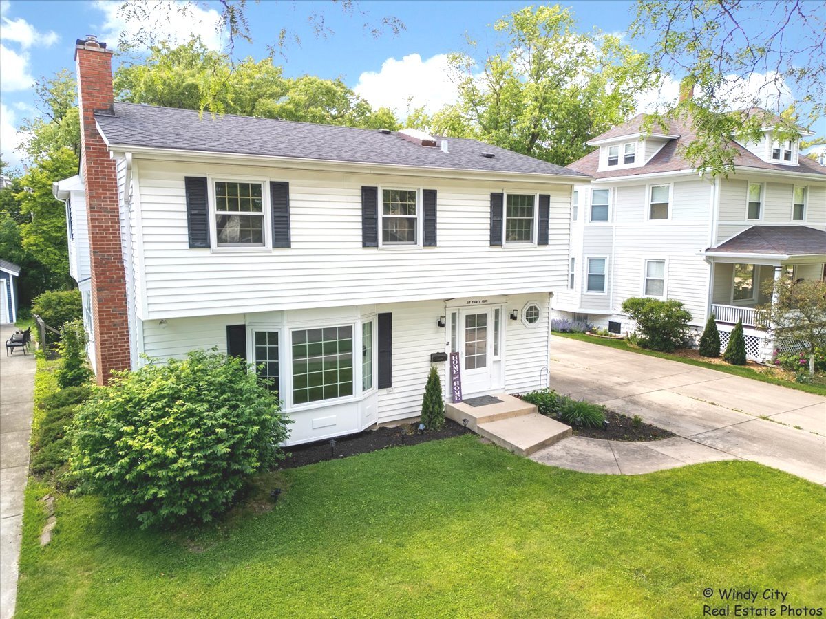 a view of a house with a backyard and a patio