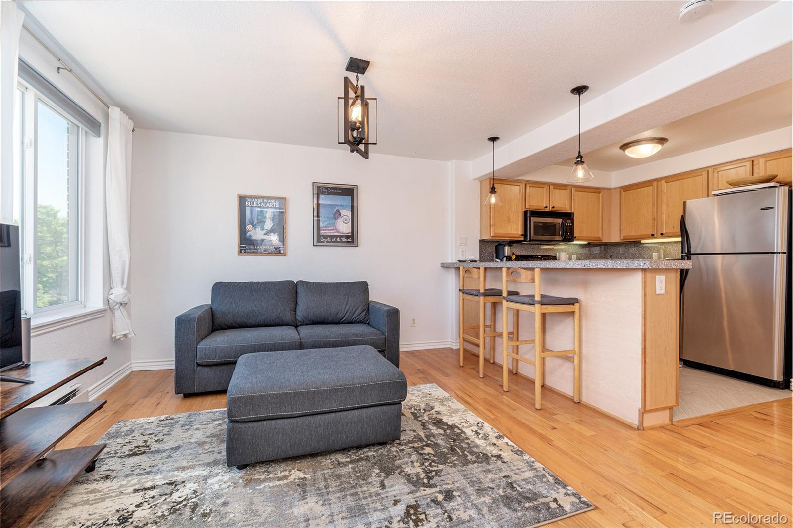 a living room with furniture and a kitchen view