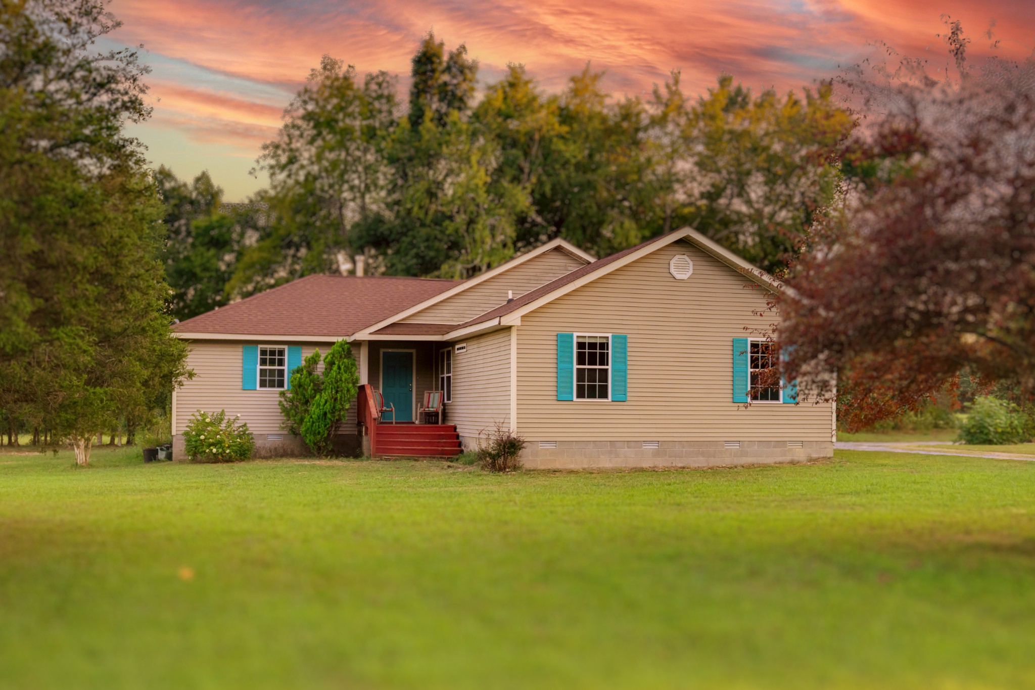 a front view of a house with yard and green space