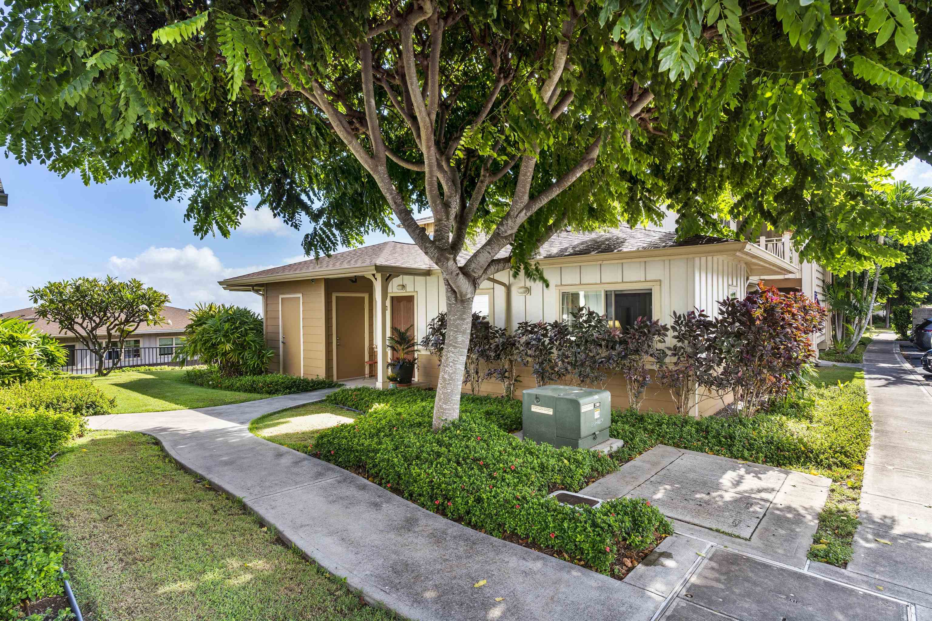 a front view of a house with a yard and potted plants