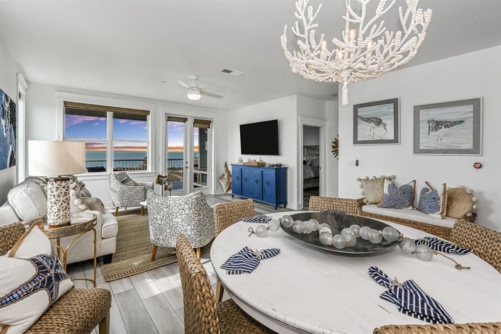 a living room with furniture a flat screen tv and a dining table