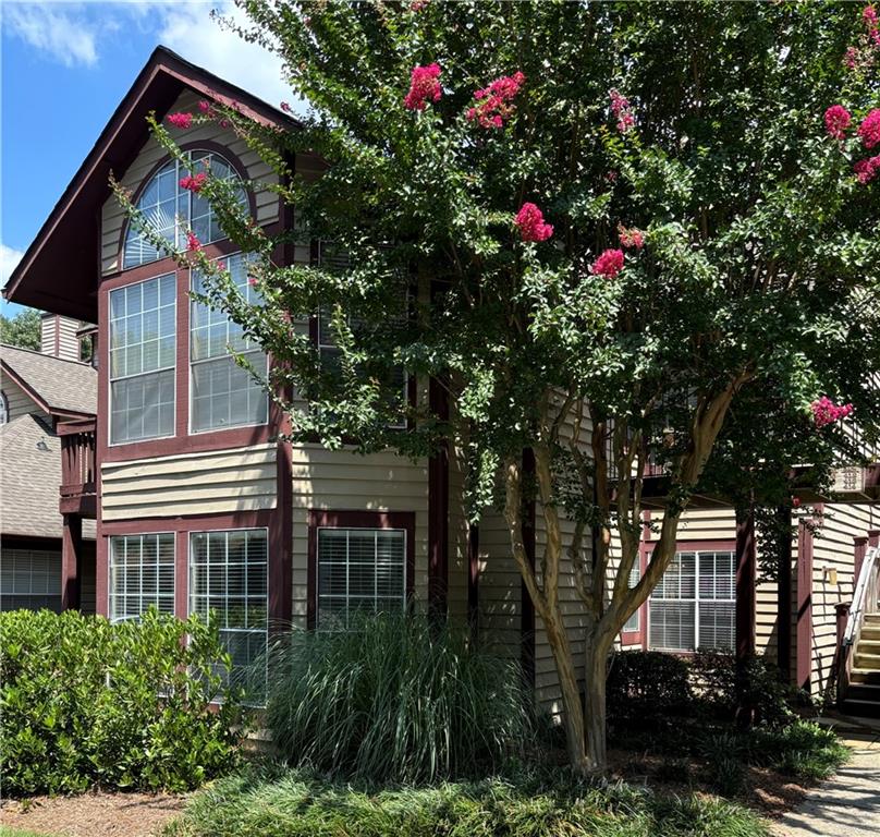 a backyard of a house with lots of trees and flowers