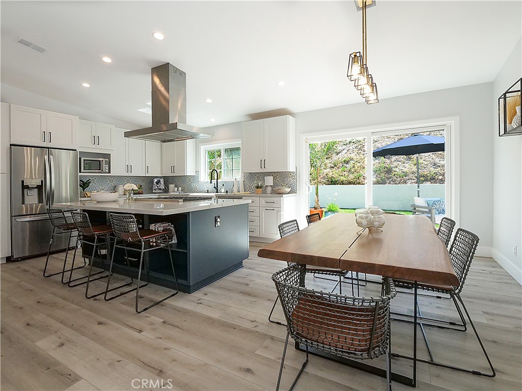 a kitchen with a table chairs a sink dishwasher window and cabinets