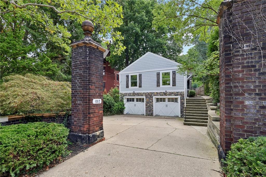 a view of a house with a yard and large tree