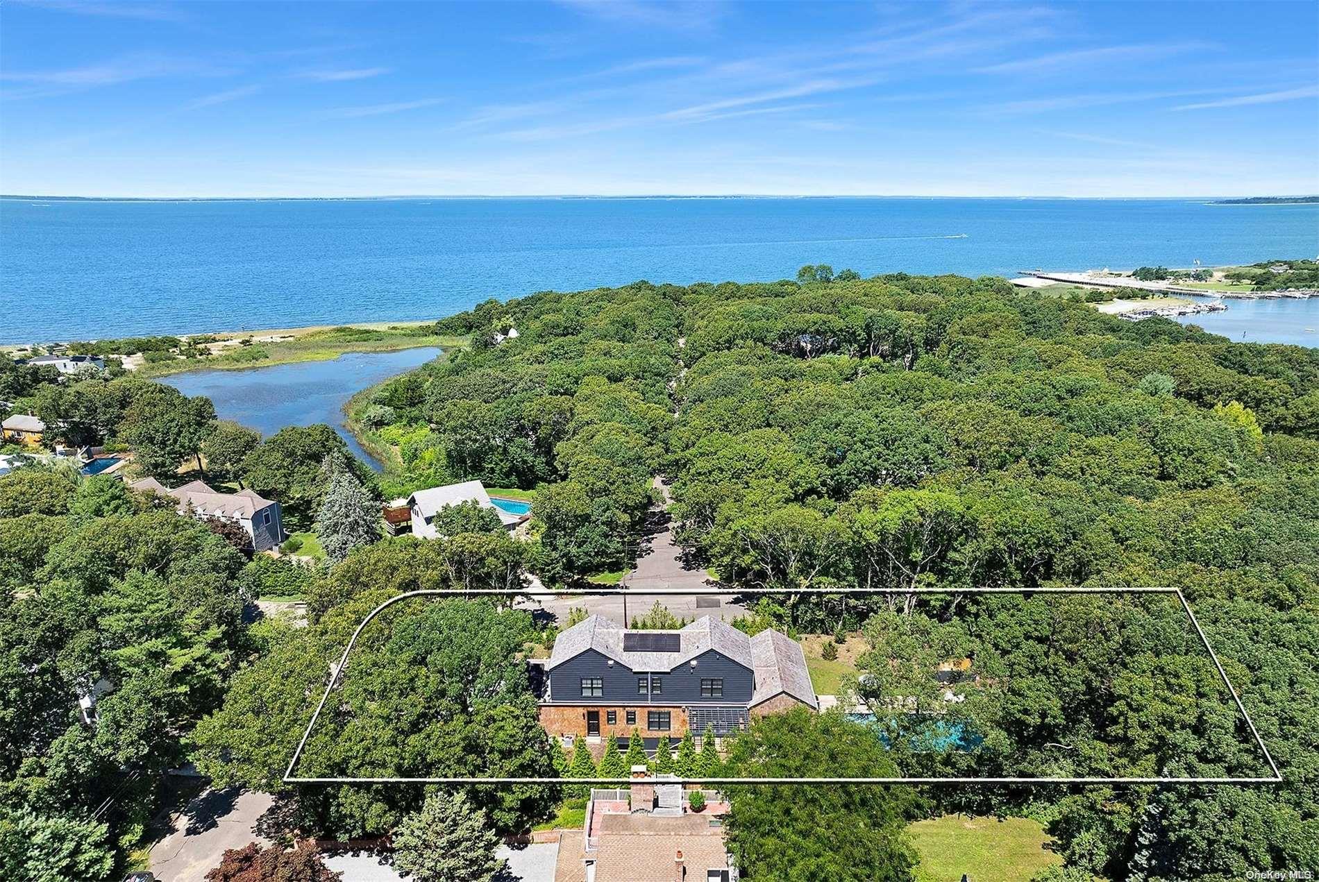 an aerial view of a city with lots of residential buildings ocean and mountain view in back