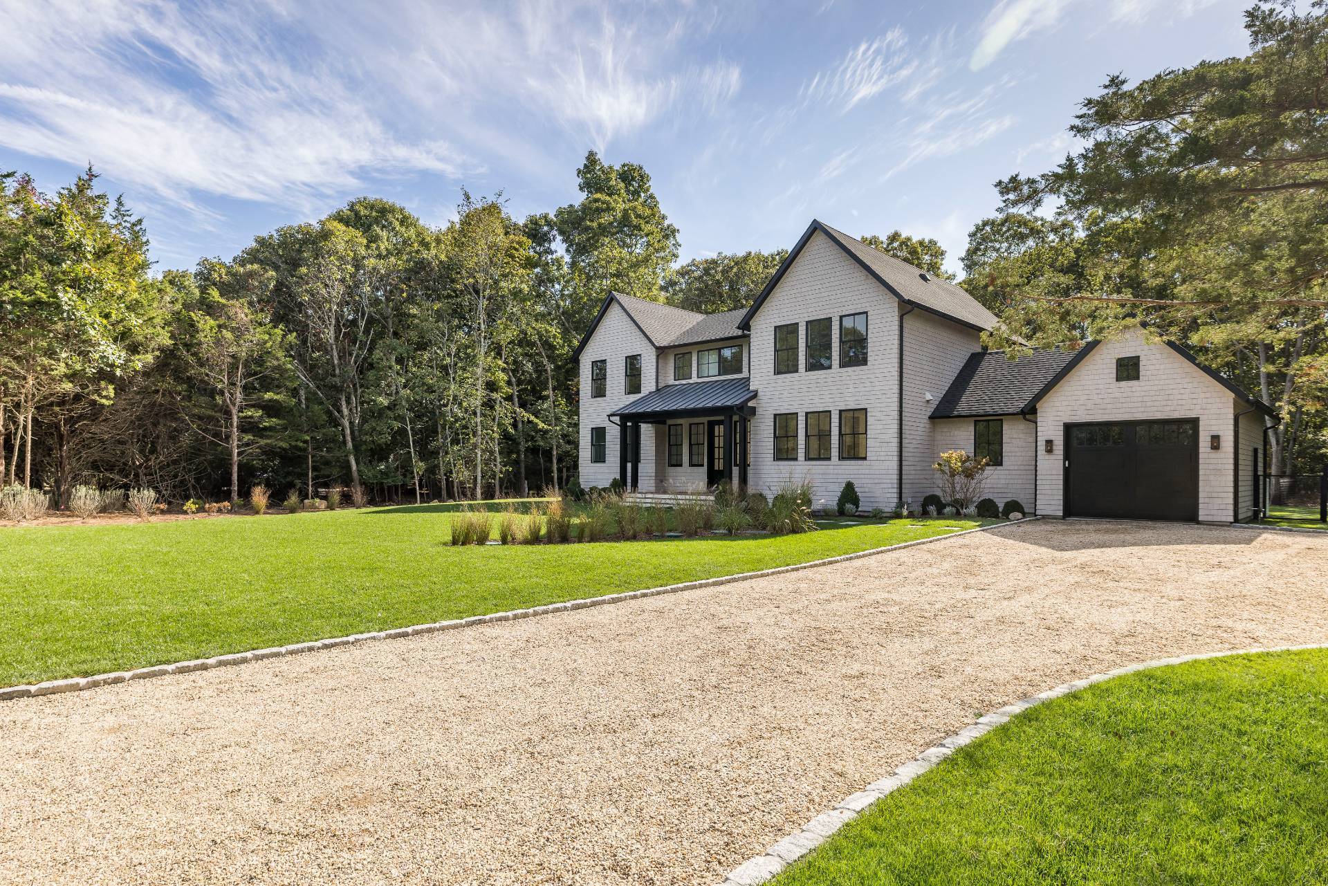 a front view of a house with a yard and trees