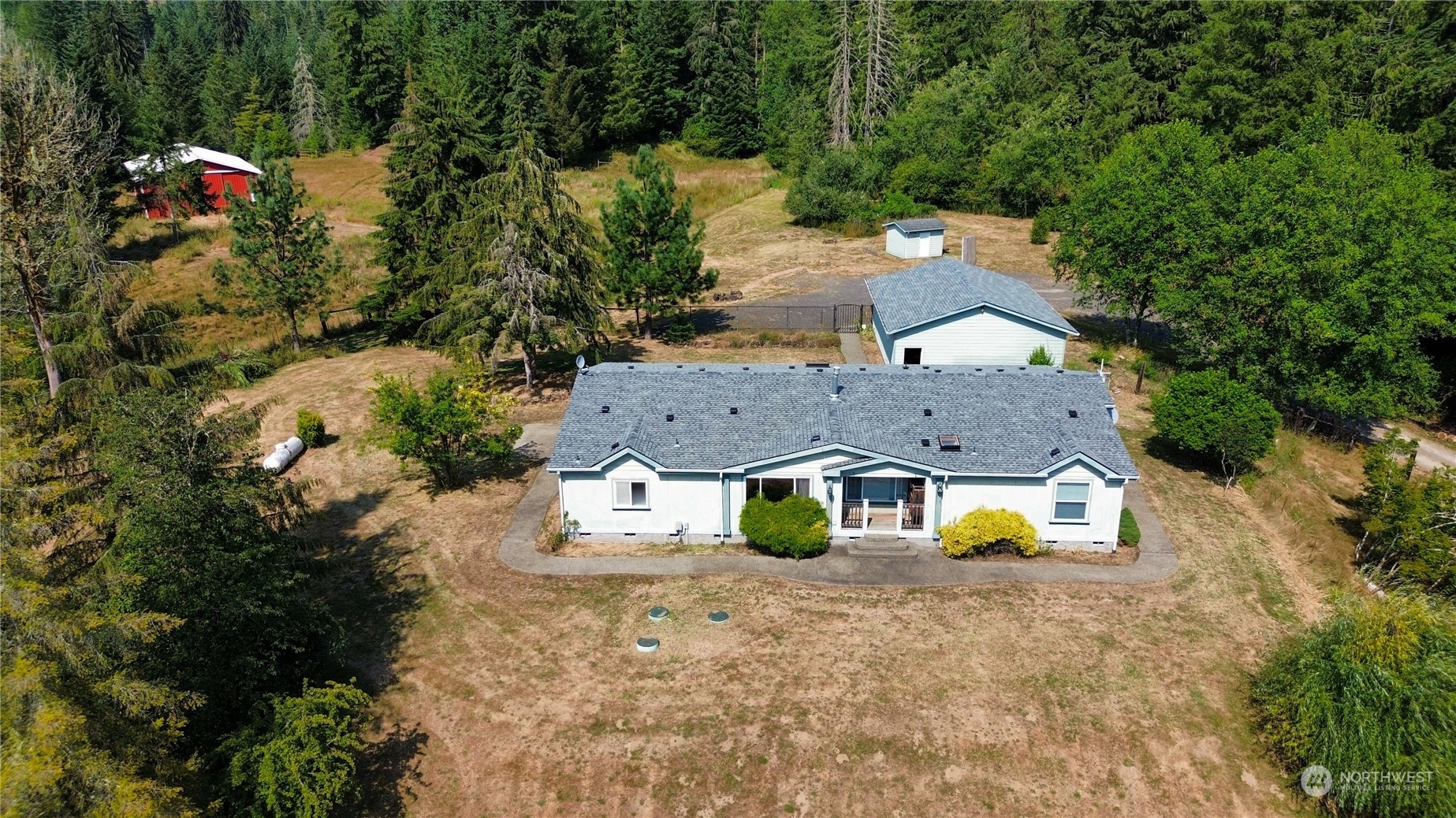 an aerial view of a house with a swimming pool big yard and large trees