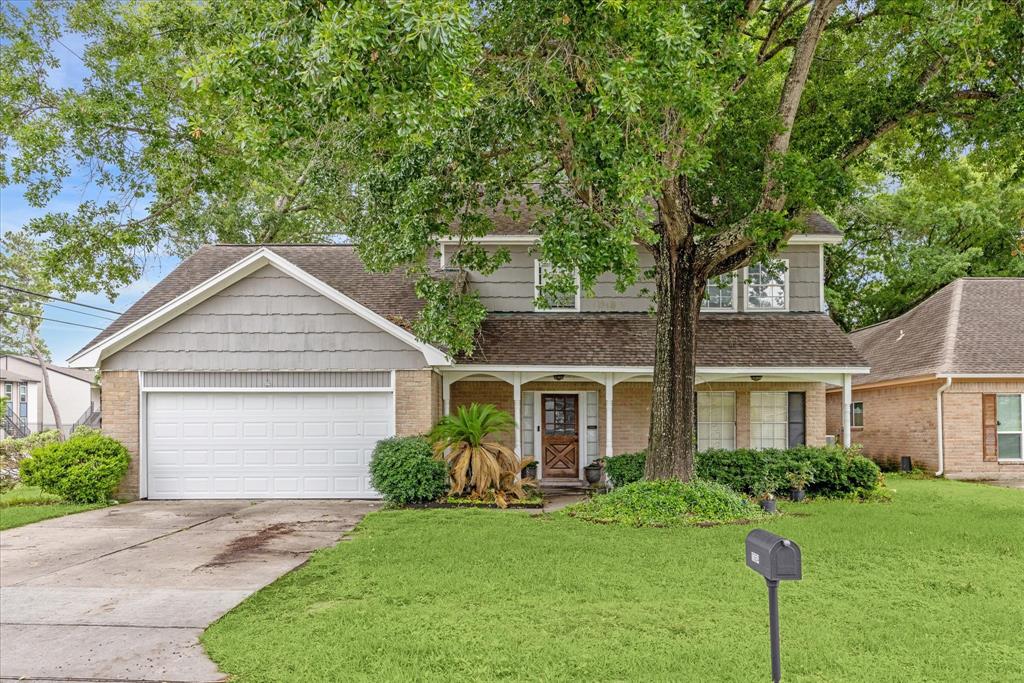 a front view of a house with a yard and trees