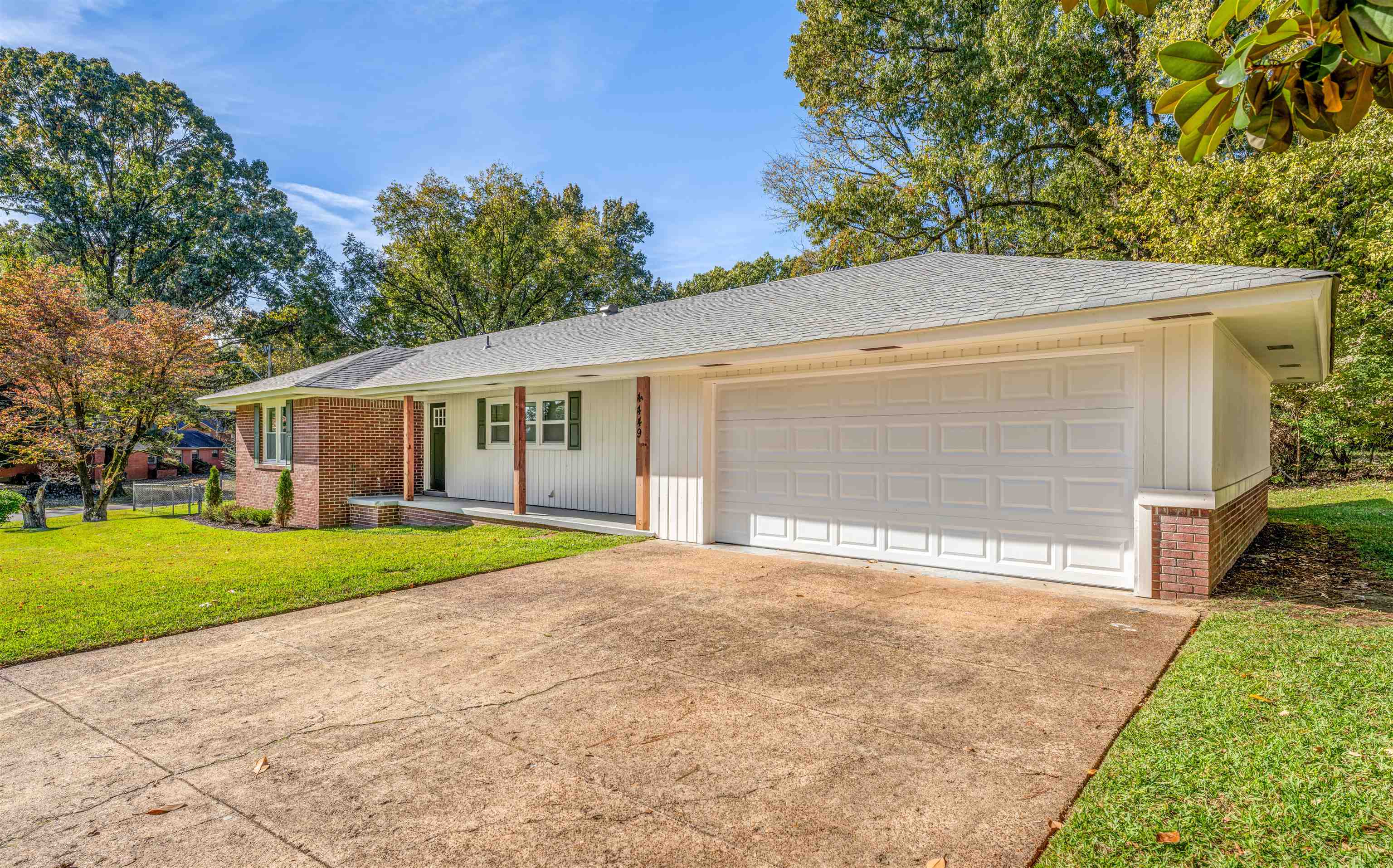 Ranch-style home featuring a garage, a porch, and a front yard