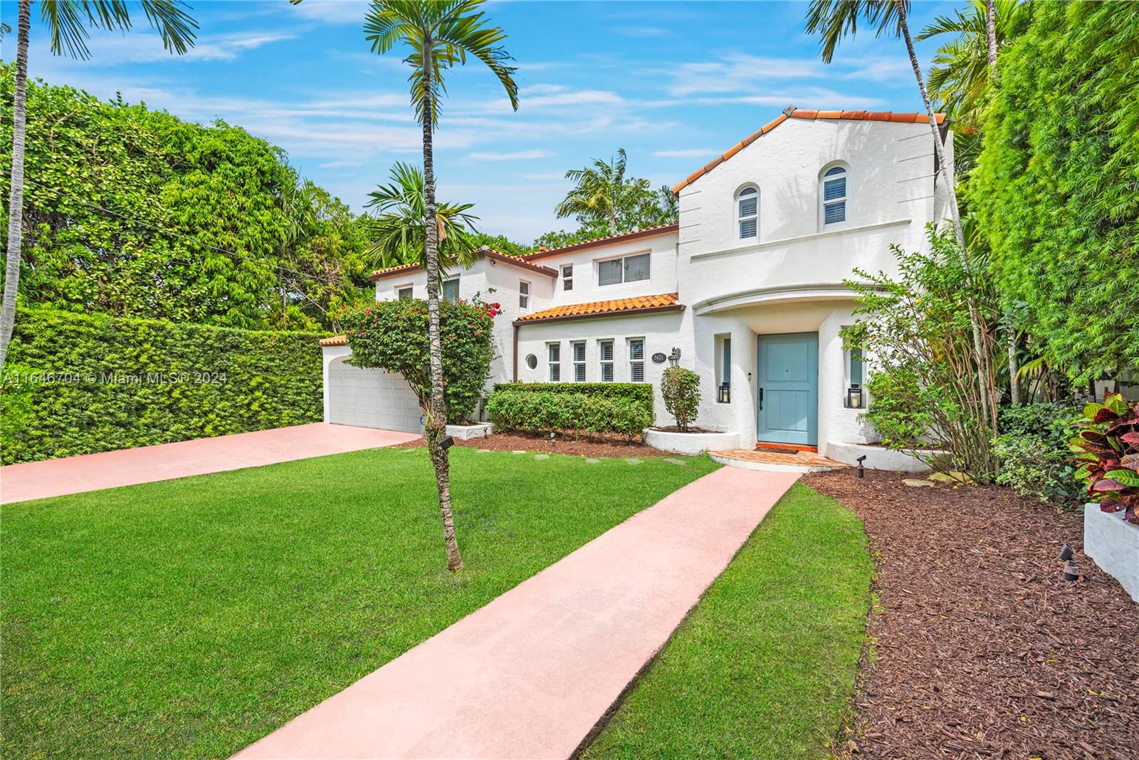 a view of a white house with a yard and potted plants