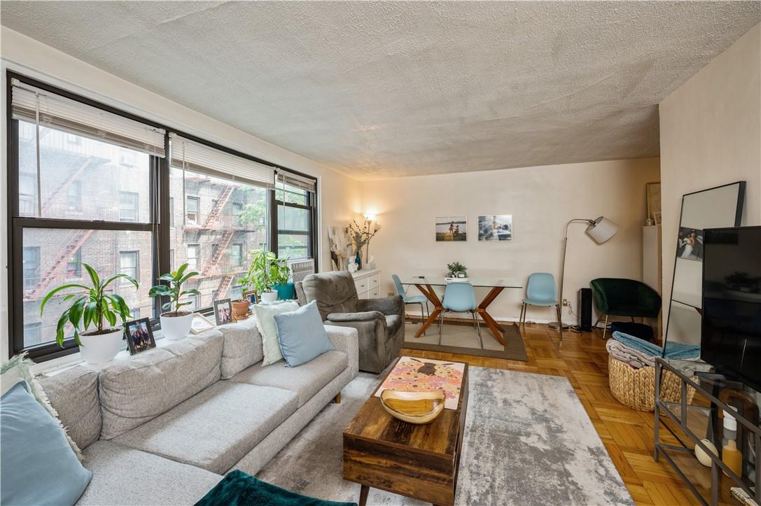 a living room with furniture a flat screen tv and a large window