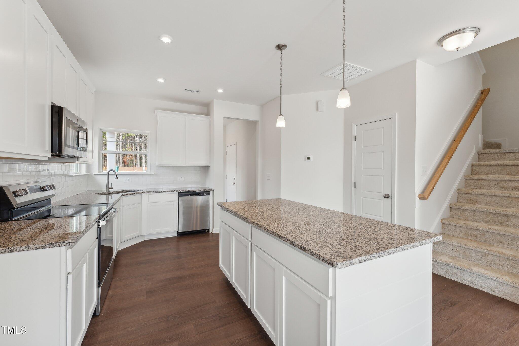 a kitchen with a stove a sink a refrigerator and a oven