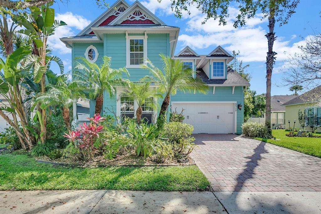 a front view of a house with a yard and potted plants