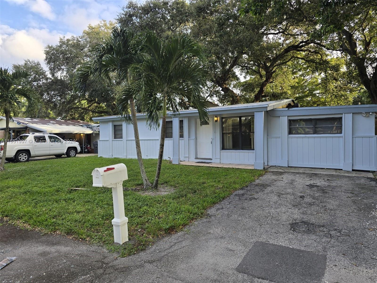 a front view of a house with a yard and trees