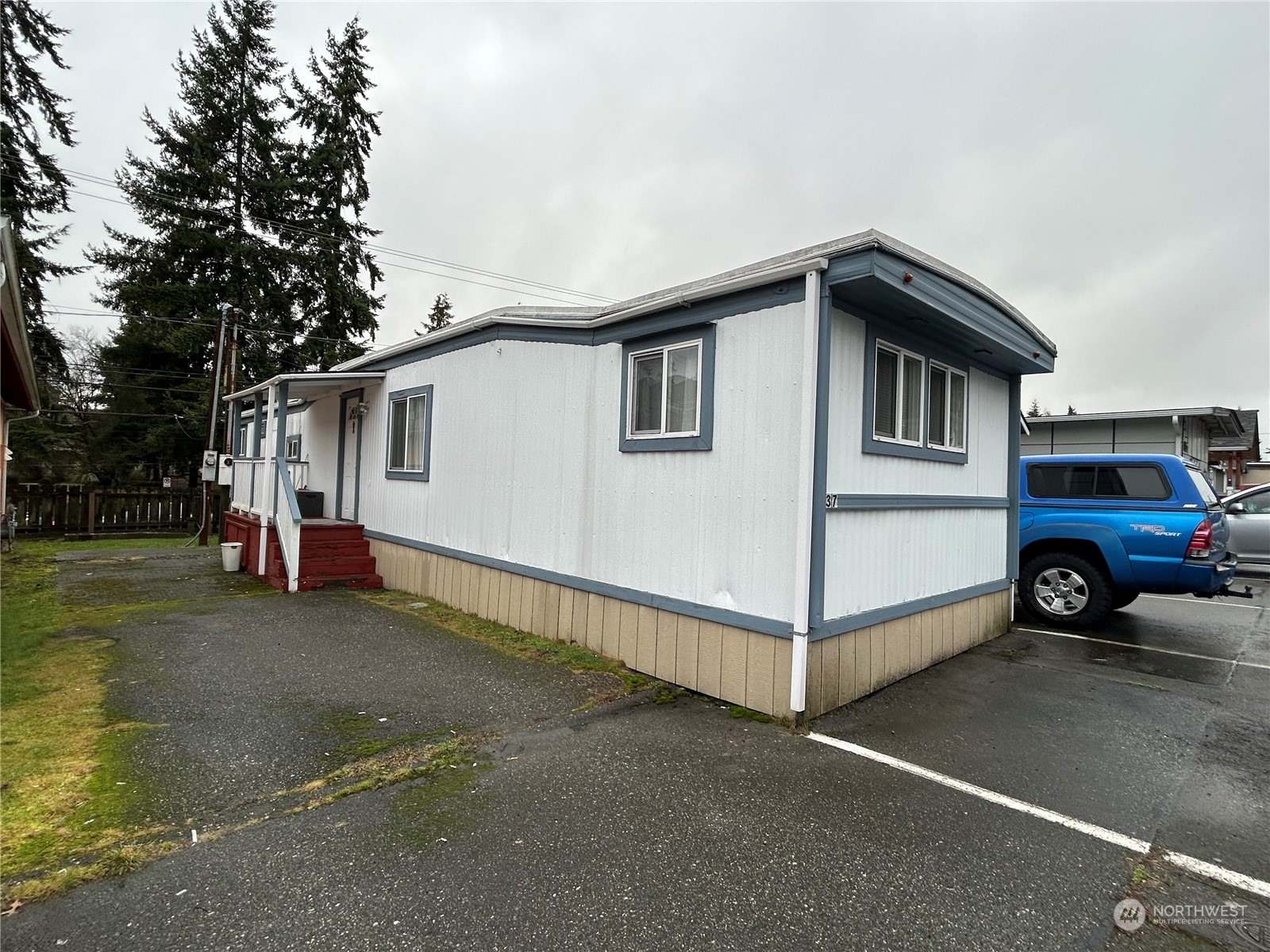 a view of a house with a yard and parking space