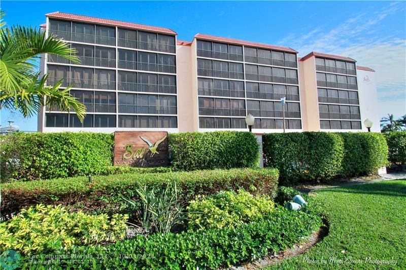 a view of front of residential apartment building with a yard