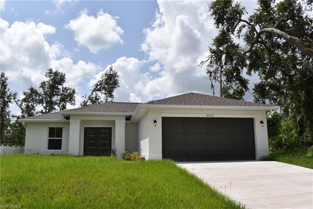 Single story home with a garage and a front lawn