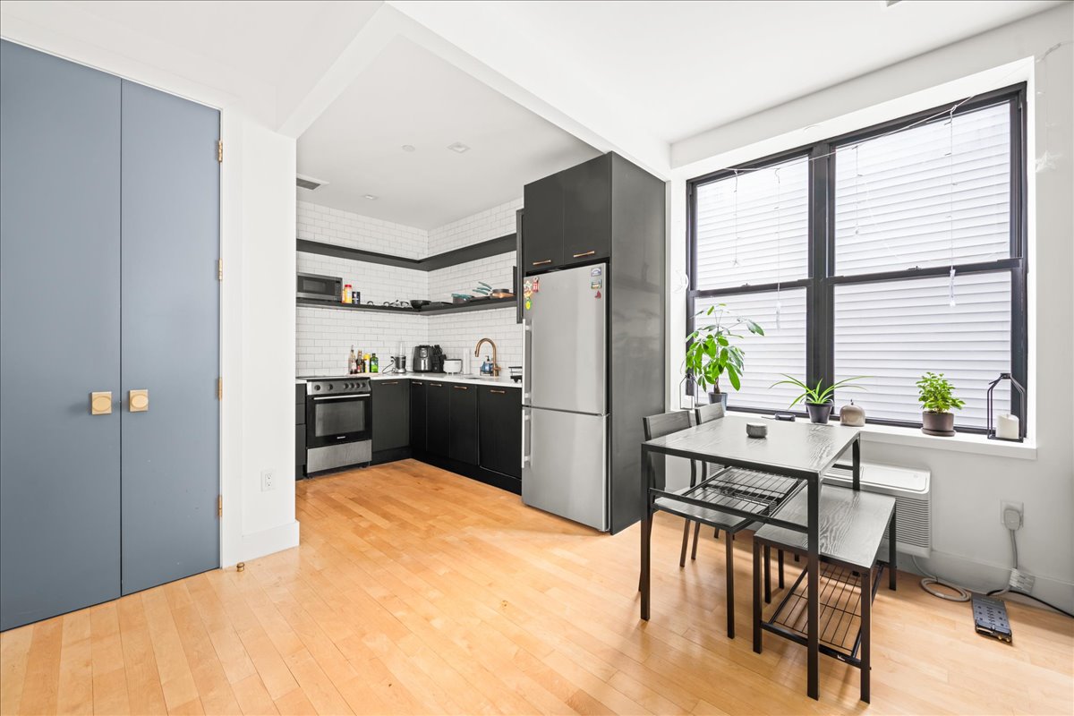 a kitchen with a table chairs refrigerator and outdoor view