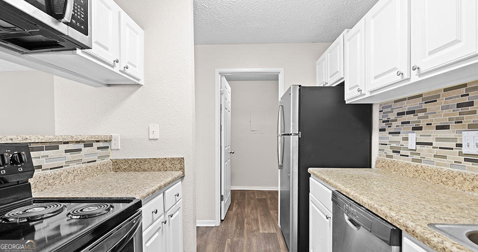 a kitchen with granite countertop a stove and a refrigerator