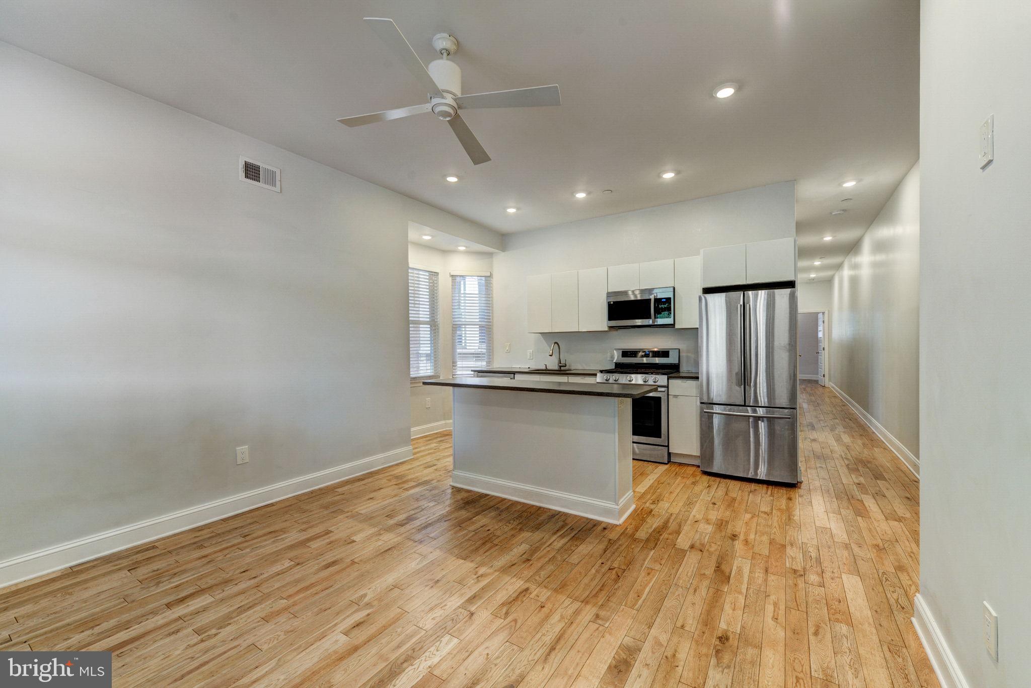 a kitchen with a refrigerator and a stove top oven