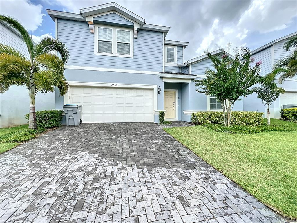 a front view of a house with a yard and a garage