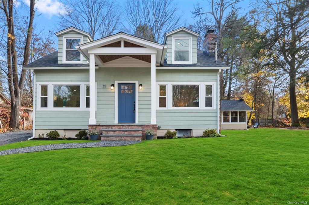 New england style home featuring a front yard and a sunroom