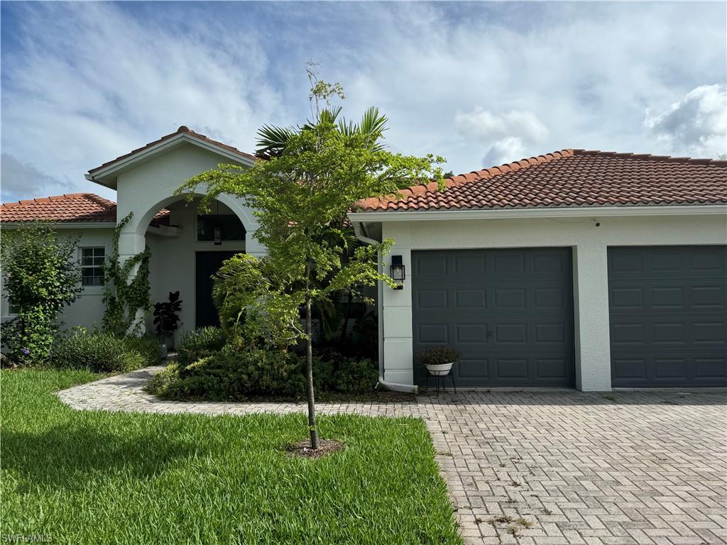 Mediterranean / spanish-style house with a front yard and a garage