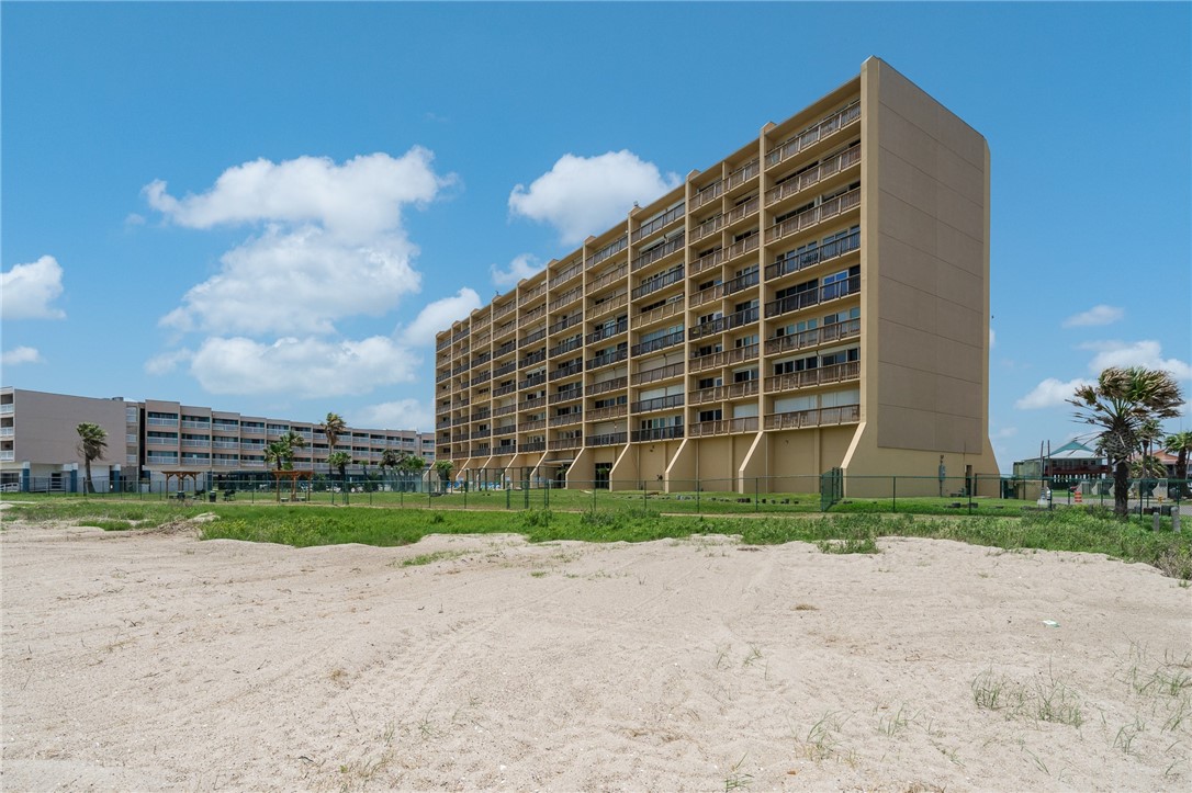 a view of a tall building next to a yard