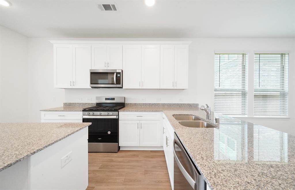 a kitchen with granite countertop a sink and a stove top oven